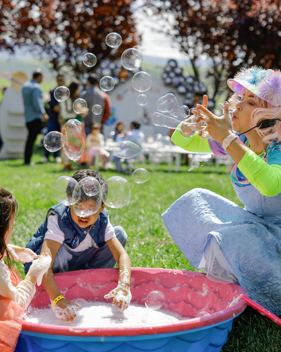 Miss Molly and children playing with bubbles