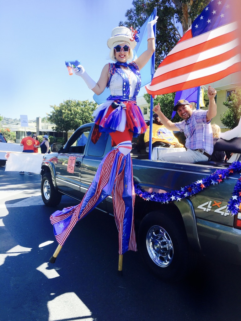 Miss Molly on stilts in a red, white, and blue parade costume