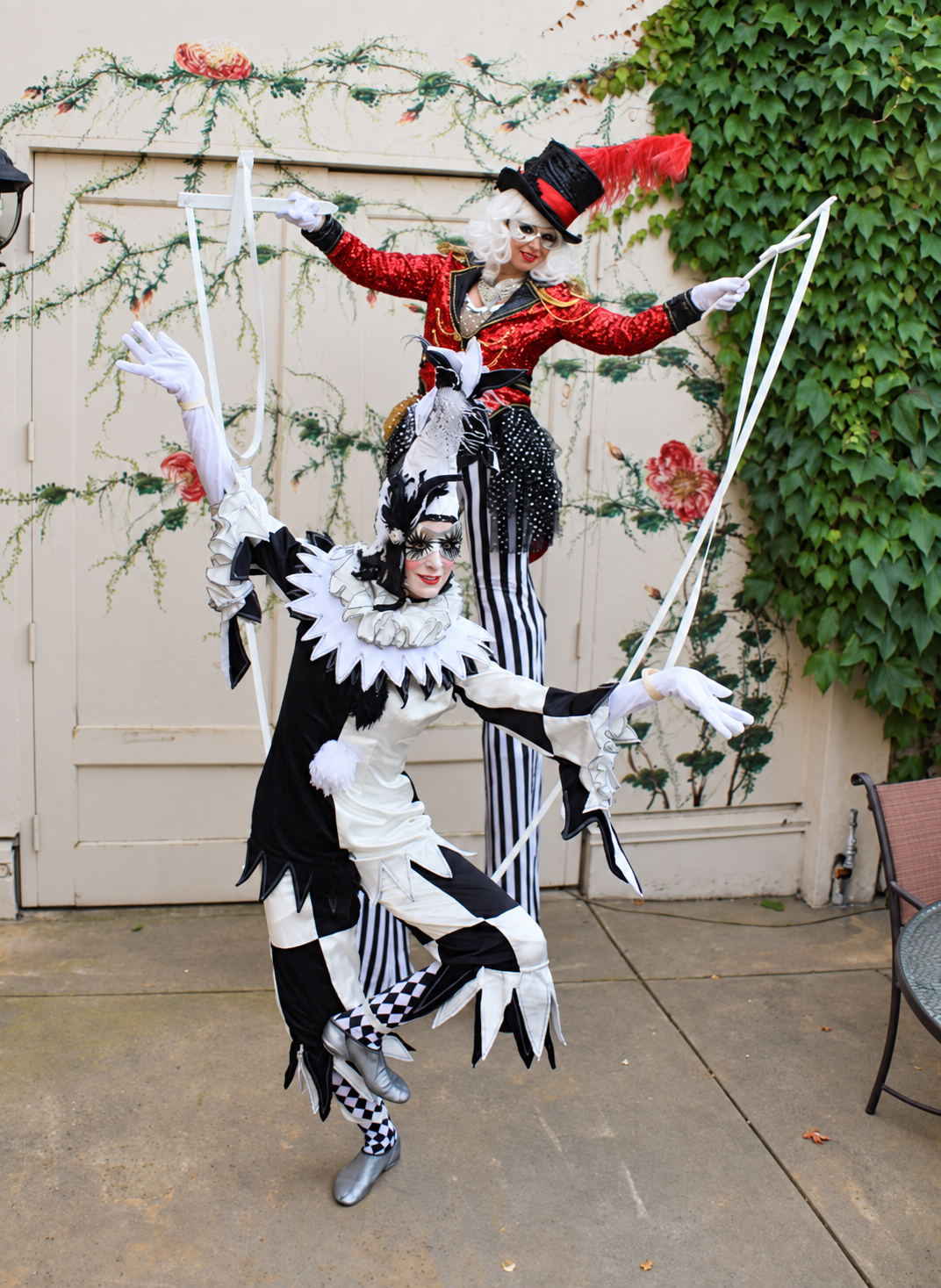 Ringmaster on stilts posing with a marionette performer